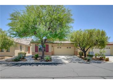 Charming single-story home featuring a desert landscape, two-car garage and ample trees in front at 5916 Sorto Lago St, North Las Vegas, NV 89081