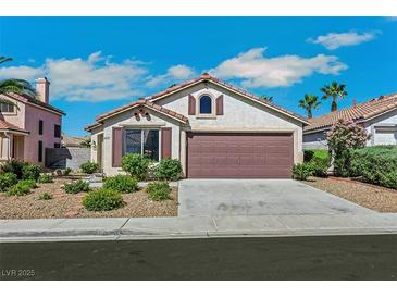 Charming single-story home showcasing a well-manicured front yard and a two-car garage at 6035 Shadow Oak Dr, North Las Vegas, NV 89031