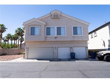 Two-story tan home featuring a three-car garage and tidy landscaping at 6459 Rusticated Stone Ave # 103, Henderson, NV 89011