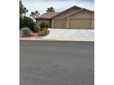 Charming single-story home with a two-car garage, landscaped front yard, and desert-friendly landscaping at 819 Sandsprings St, Henderson, NV 89011