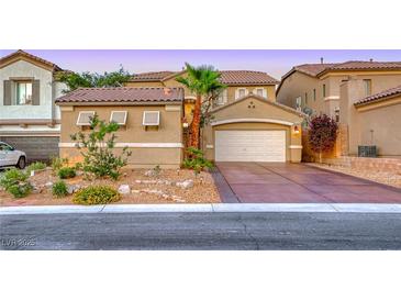 Inviting home features desert landscaping, an attached two-car garage, and a private front yard at 11334 Patores St, Las Vegas, NV 89141