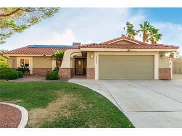 Inviting single-story home featuring a well-manicured lawn, desert landscaping, and an attached two-car garage at 1393 Calmview Pl, Las Vegas, NV 89110