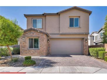 Charming two-story home featuring brick accents, a paved driveway, and a well-maintained front yard with lush greenery at 3195 Hazy Hills Ave, Henderson, NV 89052