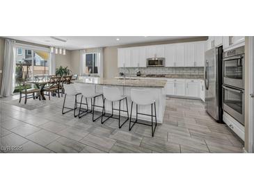 Modern kitchen boasts stainless steel appliances, granite countertops, and an island with bar seating at 3195 Hazy Hills Ave, Henderson, NV 89052