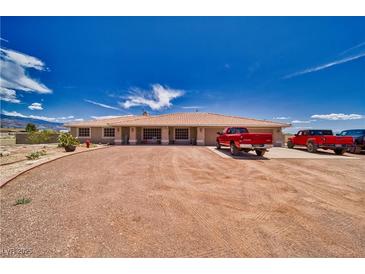 Expansive single-story home boasts a large gravel driveway and inviting curb appeal under a clear blue sky at 3251 S Parkridge Ave, Pahrump, NV 89048