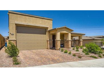 Charming single-Gathering home featuring a two-car garage, beautiful brick driveway and desert landscaping at 6098 Avery Pointe St, Las Vegas, NV 89166