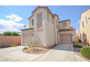 Two-story home featuring dual garages, desert landscaping, and stucco exterior at 6098 Darkfeather Way, Las Vegas, NV 89139