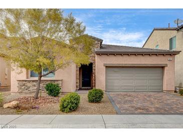 Charming single-story home with a two-car garage, desert landscaping, and a stone facade accent at 907 Gallery Course Dr, Las Vegas, NV 89148
