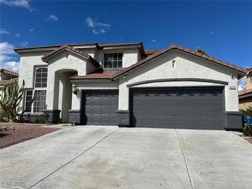 Beautiful two-story home with stucco exterior, dual garage doors, and well-maintained landscaping at 9272 W Viking Rd, Las Vegas, NV 89147