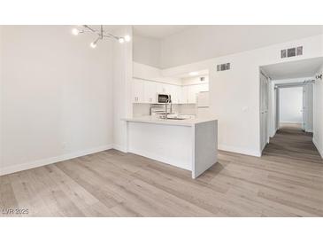 Bright kitchen with white cabinets, an island with countertop seating and stainless steel appliances at 2251 Wigwam Pkwy # 424, Henderson, NV 89074