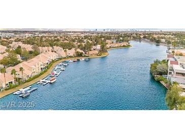 Expansive aerial view of waterfront homes with private docks and the city skyline in the background at 2608 Sun Reef Rd, Las Vegas, NV 89128