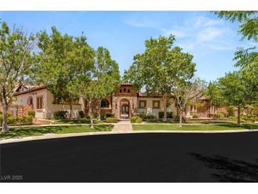 Stunning single-story home featuring lush trees, decorative stone facade, and a tiled roof at 38 Pebble Dunes Ct, Las Vegas, NV 89141