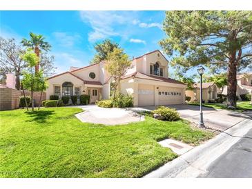 Charming two-story home boasts a lush green lawn, mature trees, and a three-car garage at 5381 Waving Sage Dr, Las Vegas, NV 89149