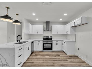 Bright kitchen features white cabinets, stainless steel appliances, and marble countertops at 5617 Reiter Ave, Las Vegas, NV 89108