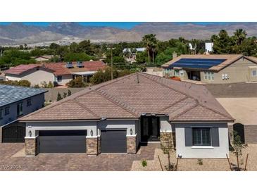 Charming single-story home featuring a beautiful roof, three-car garage, and mountain views in the background at 5851 Slate Rock Ct, Las Vegas, NV 89149