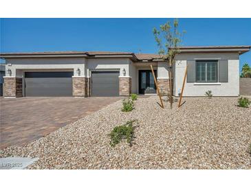 Charming single-story home with a three-car garage and low-maintenance desert landscaping at 5851 Slate Rock Ct, Las Vegas, NV 89149
