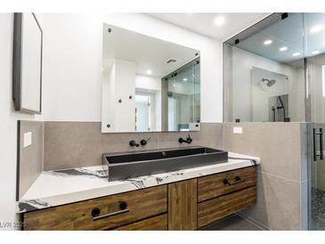 Modern bathroom features a vessel sink, marble countertops, and a glass-enclosed shower at 902 Possum Hill St, Henderson, NV 89014