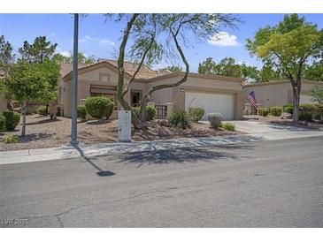 Inviting single-story home with a two-car garage, desert landscaping, and a tiled roof at 10017 Bundella Dr, Las Vegas, NV 89134