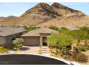 Beautiful single-story home with desert landscaping and brick driveway in front of a mountain at 10890 Red Yucca Dr, Las Vegas, NV 89138