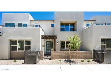Contemporary home exterior with a covered entrance, block wall and desert landscaping at 1485 Melodic Lark Ln, Las Vegas, NV 89138