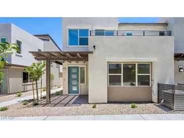 Modern two-story home features a covered entry, blue door, gray gravel landscaping and a second story patio at 1491 Melodic Lark Dr, Las Vegas, NV 89138