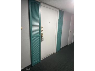 Apartment front door flanked with teal colored shutters at 3930 University Center Dr # 901, Las Vegas, NV 89119