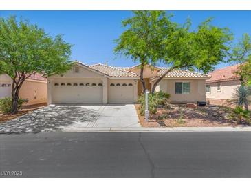 Charming single-story home with a tile roof, mature trees, and a spacious three-car garage at 4029 Ricebird Way, North Las Vegas, NV 89084