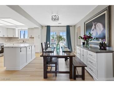 Bright dining area features an elegant table and a modern light fixture, seamlessly connected to the kitchen at 4981 E Pawnee Pl, Pahrump, NV 89061