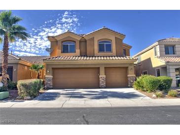 Two-story home featuring a two-car garage, desert landscaping and a tile roof at 72 Broken Putter Way, Las Vegas, NV 89148