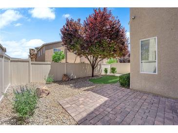 Private backyard with a patio, rock landscaping, and beautiful tree at 8562 Burning Bridge Ct, Las Vegas, NV 89131