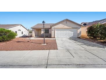 Charming single-story home featuring a two-car garage and desert landscaping for easy maintenance at 905 Harp Way, North Las Vegas, NV 89032