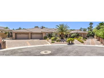 Attractive stone and stucco home features a spacious three-car garage and mature landscaping at 9135 Hickam Ave, Las Vegas, NV 89129