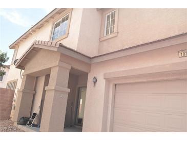 Two-story home featuring a covered porch, attached garage, and stucco exterior at 1025 Appaloosa Hills Ave, North Las Vegas, NV 89081