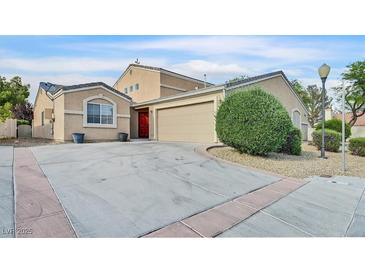Charming single-story home featuring a two-car garage, red front door, and well-maintained landscaping at 4708 Cohiba Way, North Las Vegas, NV 89031