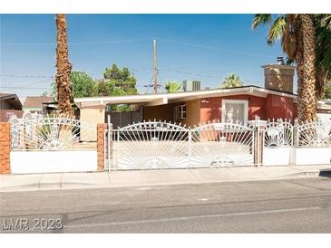 Charming single story home with a unique decorative metal fence and desert landscaping at 624 N Bruce St, Las Vegas, NV 89101