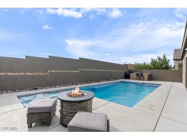 Beautiful backyard with a pool, hot tub, fire pit, and outdoor seating area, perfect for entertaining and relaxation at 6421 Winecup St, Las Vegas, NV 89149