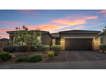 Charming single-story home featuring desert landscaping, a paver driveway and walkway, and a two car garage at 6421 Winecup St, Las Vegas, NV 89149