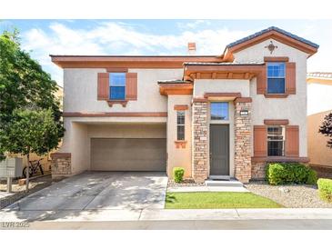 Charming two-story home featuring stucco siding, decorative shutters, and a convenient attached two-car garage at 135 Manor House Ave, Las Vegas, NV 89123