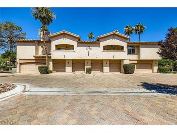 Attractive townhome exterior with garages, landscaped grounds and mature trees under a clear blue sky at 2050 W Warm Springs Rd # 3624, Henderson, NV 89014