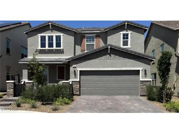 Two-story home with a gray exterior, a two-car garage, and manicured landscaping at 2645 Cava Tirreni St, Henderson, NV 89044