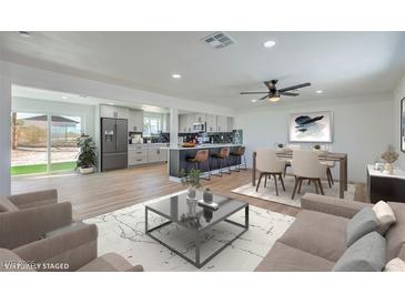 Open-concept living area with a modern kitchen, dining space, and a sliding glass door to the backyard at 5200 Blanton Dr, Las Vegas, NV 89122
