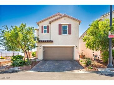 Charming two-story home with desert landscaping, and a brown garage door at 7990 Formitch Ct, Las Vegas, NV 89166