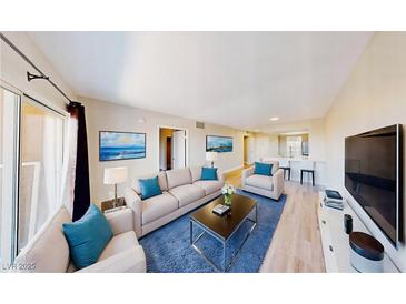 Bright living room featuring stylish furniture, blue accent pillows, and sleek decor creating an inviting space at 8070 W Russell Rd # 1046, Las Vegas, NV 89113