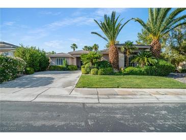 Charming single story home with lush landscaping, mature palm trees, and a spacious driveway at 10320 Luxembourg Ave, Las Vegas, NV 89145