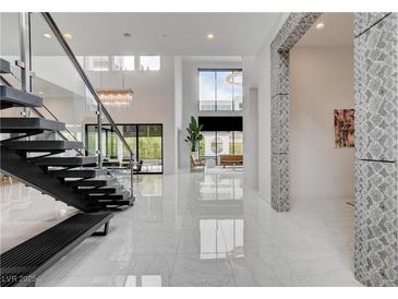 Grand foyer featuring soaring ceilings, marble floors, modern staircase and an open floor plan bathed in natural light at 10752 Patina Hills Ct, Las Vegas, NV 89135