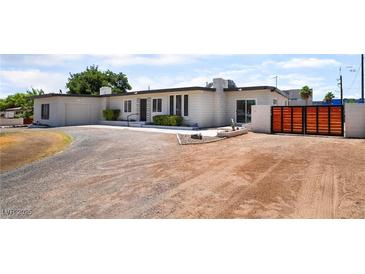 Charming single-story home with a long driveway and a modern orange-and-black gate at 5617 Alfred Dr, Las Vegas, NV 89108