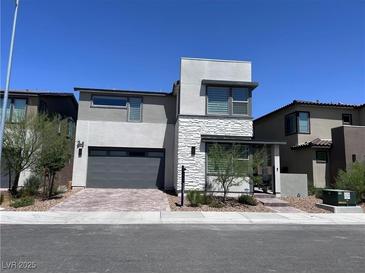 Modern two-story home featuring a two-car garage, stone accents, and contemporary architectural details at 6927 Desert Finch St, North Las Vegas, NV 89084