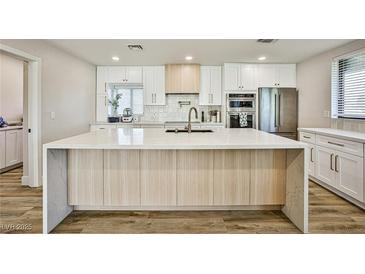 Bright kitchen featuring a large island, stainless steel appliances, and stylish white cabinetry at 9340 W Washburn Rd, Las Vegas, NV 89149