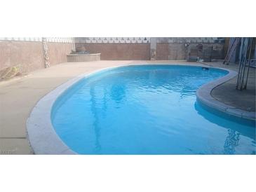 Large in-ground pool with blue water, concrete patio and landscaping surrounding the property at 5178 Wilbur St, Las Vegas, NV 89119
