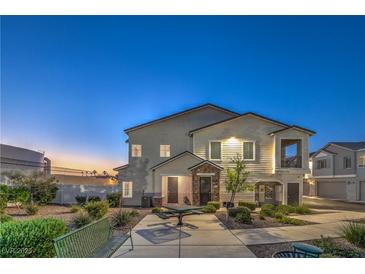 Inviting home exterior featuring a charming covered porch, meticulous landscaping, and warm exterior lighting at 545 Thea St # 1315, Henderson, NV 89052
